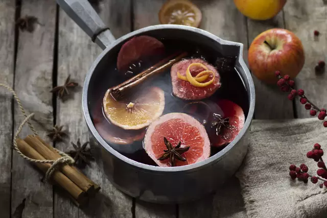 Glühwein im Topf mit Gewürzen. Orangenscheiben, Vanille, Zimt, Äpfel